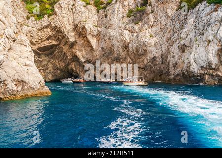 CAPRI, ITALIEN - 19. SEPTEMBER 2023: Touristen in Booten machen Fotos von der Grünen Grotte auf Capri. Stockfoto