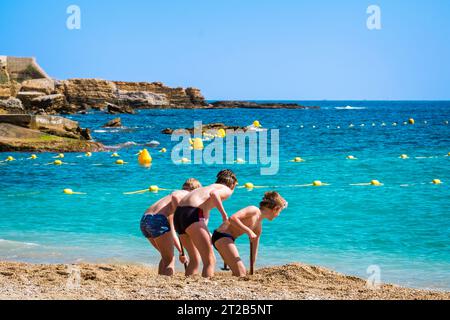 Drei kleine Jungs graben im Sand am Strand von Cassis, Südfrankreich. Stockfoto