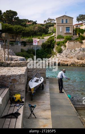 Ein einsamer Mann fischt im Hafen von Cassis, Südfrankreich. Stockfoto