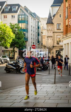 Eine Gruppe von Läufern joggt durch die Straßen des Viertels Le Marais in Paris, Frankreich. Stockfoto