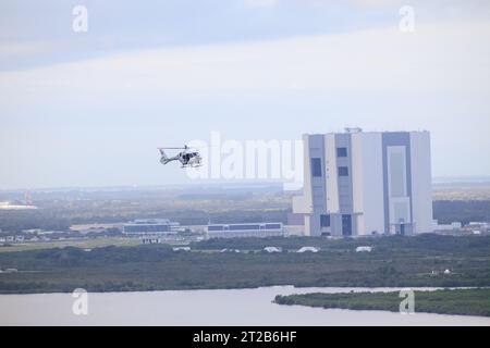 Ein NASA-Helikopter begleitet die Artemis II-Astronauten Reid Wiseman, Victor Glover, Christina Koch und CSA-Astronauten Jeremy Hansen, während sie am 20. September 2023 vom Neil Armstrong Operations and Checkout Building zum Launch Pad 39B in Besatzungsfahrzeugen fahren. Stockfoto