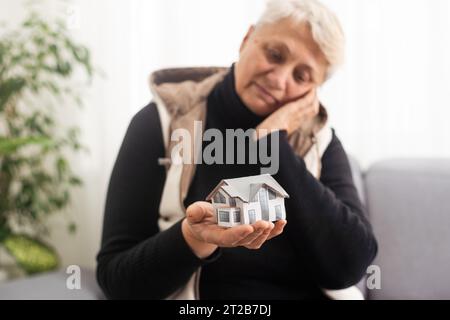 Eine glückliche maklerin, die ein kleines Hausmodell in der Hand hält, Handfläche, Objekt vor der Kamera zeigt, Agenturservice fördert, beim Haus hilft, Grundstückskauf Stockfoto