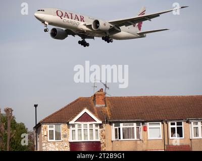 London Heathrow Airport Hounslow Qatar Cargo, betrieben von Qatar Airways Boeing 777-FDZ Flugzeuge auf dem Landeanflug auf Tiefflug über Wohnhäusern Stockfoto