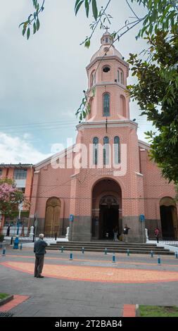 Otavalo, Imbabura/Ecuador - 14. Oktober 2023: Mann geht an einem bewölkten Tag vor der Kathedrale von Otavalo Stockfoto