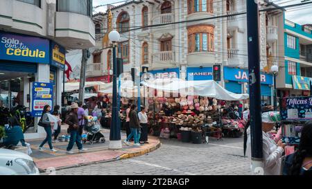 Otavalo, Imbabura / Ecuador - 14. Oktober 2023: Menschen laufen durch das Stadtzentrum vor dem Straßenmarkt Stockfoto