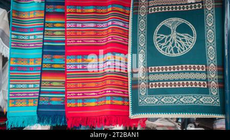 Otavalo, Imbabura/Ecuador - 14. Oktober 2023: Details von Stoffen mit einem Design aus mehrfarbigen Linien und Streifen, die auf dem Kunsthandwerksmarkt hängen Stockfoto