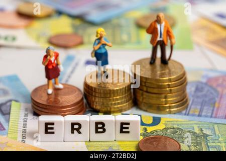 Augsburg, Bayern, Deutschland. Oktober 2023. Buchstabenwürfel bilden das Wort Erbe. Miniaturfiguren auf Münzgeldstapel neben Euro-Barscheine. Symbol Bildvererbung *** Buchstabenwürfel bilden das Wort Erbe. Miniaturfiguren auf Münzgeld Stapel neben Euro Bargeld Scheinen. Symbolbild Erbschaft Credit: Imago/Alamy Live News Stockfoto