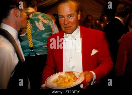 Hunt Breakfast, Master of the Foxhounds, MFH in traditionellem Jagdrosa, hat er sich in der Warteschlange gestellt und wird jetzt sein Frühstück serviert. Alle waren die ganze Nacht wach. Tysoe, Warwickshire, England, April 1982. HOMER SYKES AUS DEN 1980ER JAHREN. Stockfoto