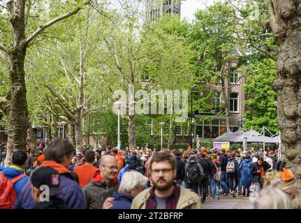 Große Gruppe von Menschen, die im Park spazieren und den Königstag feiern. AMSTERDAM, NIEDERLANDE-28. APRIL 2019 Stockfoto