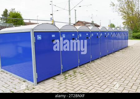 Überdachte blaue Boxen zur Aufbewahrung von Fahrrädern am Bahnhof. Stockfoto