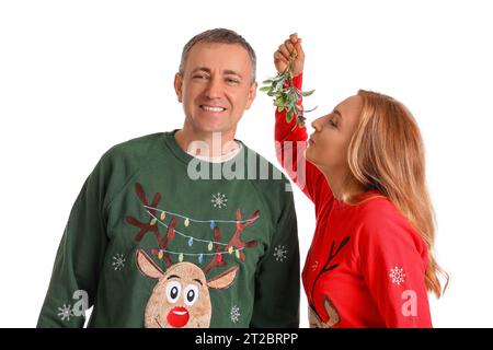 Reifes Paar küssen unter Mistelzweig auf weißem Hintergrund Stockfoto