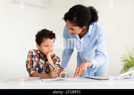 Wütende Lehrerin schimpft Schülerjungen in der Klasse Stockfoto