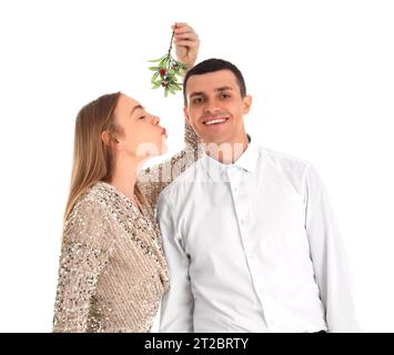 Junges Paar küsst unter Mistelzweig auf weißem Hintergrund Stockfoto