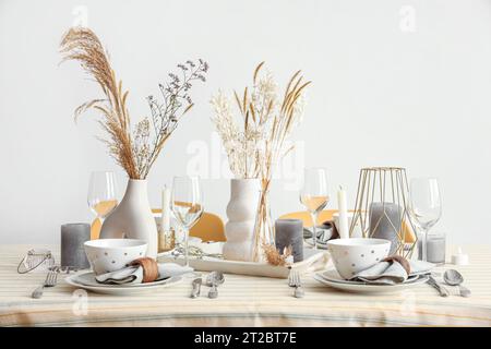 Eleganter Tisch mit Pampasgras, getrockneten Blumen und Geschirr im Speisesaal Stockfoto