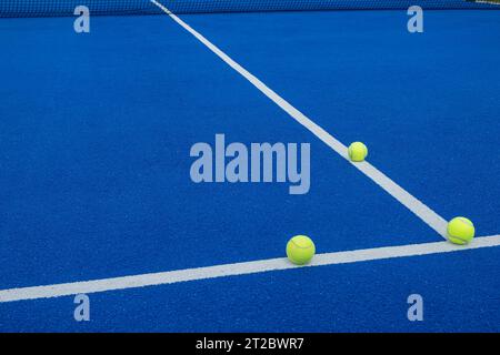 Drei Kugeln auf den Linien eines blauen Paddle-Tennisplatzes Stockfoto