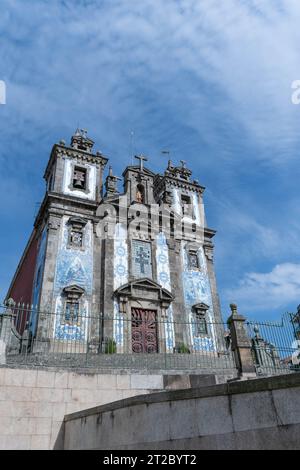 Historische portugiesische Kirche mit verzierten blauen Azulejo-Fliesen vor dem bewölkten Himmel in Porto Stockfoto