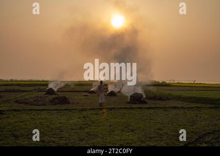 Verbrennung landwirtschaftlicher Abfälle - Smog und Verschmutzung. Schädliche Emissionen durch die Verbrennung von Heu und Stroh in landwirtschaftlichen Feldern. Chandpur, Bangladesch Stockfoto