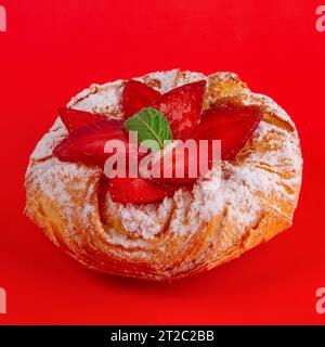 Dänisches Gebäck mit Erdbeere isoliert auf rotem Hintergrund Stockfoto