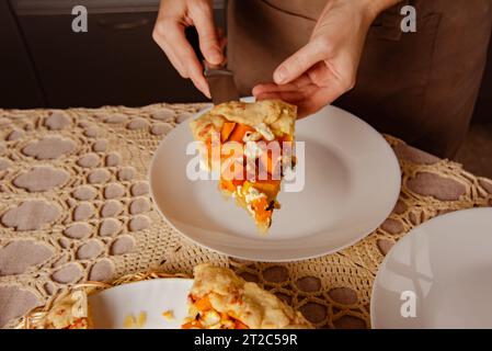Frau Hände halten hausgemachte Bäckerei - Kürbiskuchen offen, Nahaufnahme Stück Schnittkuchen Stockfoto