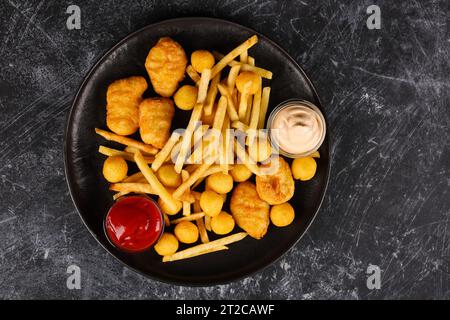 Pommes frites, Käsebällchen, Hühnchennuggets, Saucen, Blick von oben Stockfoto