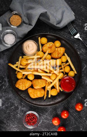 Pommes frites, Käsebällchen, Hühnchennuggets, Saucen, Blick von oben Stockfoto