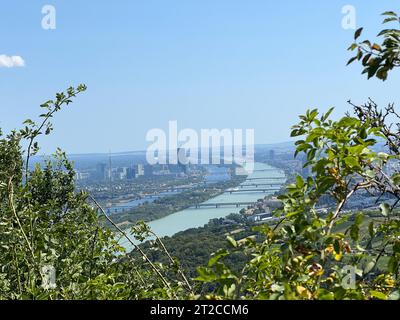 Eine malerische Aussicht auf einen Fluss gesäumt von üppig grünen Blättern und Reihen von Gebäuden auf beiden Seiten Stockfoto