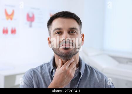 Endokrines System. Ein Mann, der sich drinnen einer Schilddrüsen-Selbstuntersuchung unterzieht Stockfoto