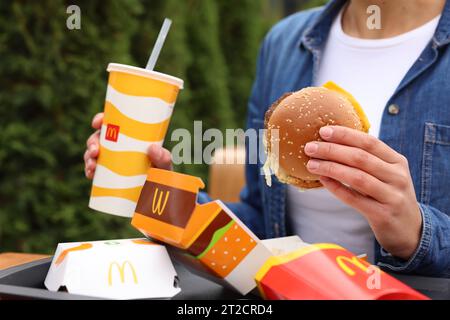 Lviv, Ukraine - 9. Oktober 2023: Frau mit McDonald's Menü am Tisch draußen, Nahaufnahme Stockfoto