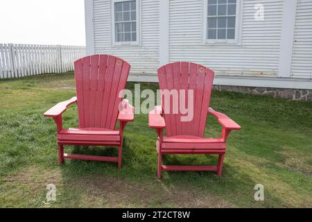 Red Adirondack Stühle an der Cape Spear National Historic Site in St. John's, Neufundland & Labrador, Kanada Stockfoto
