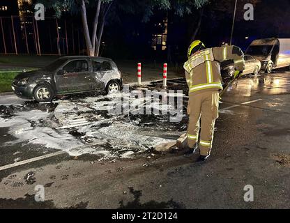 Berlin, Deutschland. Oktober 2023. Ein Feuerwehrmann räumt auf, nachdem mehrere landwirtschaftliche Fahrzeuge abgefackelt wurden. Mehrere Autos und ein LKW sind am Donnerstagabend auf der Sonnenallee in Berlin-Neukölln in Flammen aufgegangen. Quelle: Sven Kaeuler/dpa/Alamy Live News Stockfoto