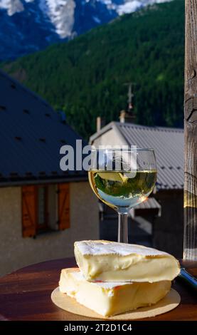 Französischer Reblochon-Käse aus Haute-Savoie, Weißwein Roussette de Savoie oder Vin de Savoie mit Blick auf das alte Alripne-Dorf und den Berg Hautes Alpes Stockfoto