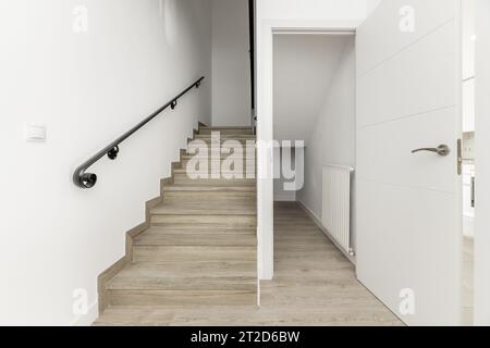 Verteilerlandung eines zweistöckigen Einfamilienhauses mit schwarzen Metallgeländern auf einer Treppe Stockfoto