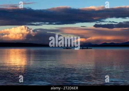 Kajakfahrer beenden den Tag am Lake Yellowstone in der Nähe von Grant Village, während die kumulativen Wolken der Gewitter am Horizont im Yellowstone National Park liegen. Stockfoto