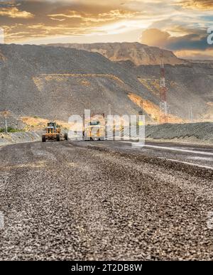 Diamantbergwerk im Tagebau, Bergbaugrader und Staubsauger, die die Schotterstraße mit Zugang zur Grube warten Stockfoto