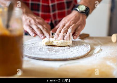 Details der Hände von Männern, die den Teig Rollen. Zubereitung zum Backen von traditionellem tschechischem Gebäck. Hausgemachte frische Speisen Stockfoto