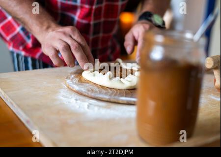 Details der Hände von Männern, die den Teig Rollen. Zubereitung zum Backen von traditionellem tschechischem Gebäck. Hausgemachte frische Speisen Stockfoto