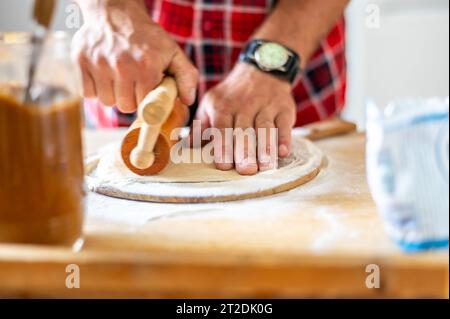 Details der Hände von Männern, die den Teig Rollen. Zubereitung zum Backen von traditionellem tschechischem Gebäck. Hausgemachte frische Speisen Stockfoto