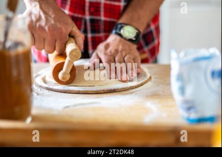 Details der Hände von Männern, die den Teig Rollen. Zubereitung zum Backen von traditionellem tschechischem Gebäck. Hausgemachte frische Speisen Stockfoto