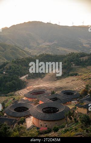 Aus der Nähe von Tulou, den einzigartigen Wohnungen von Hakka in Fujian, China. Tianluokeng Tulou Cluster, vertikales Sonnenuntergangsbild mit Kopierraum für Tex Stockfoto