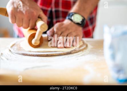 Details der Hände von Männern, die den Teig Rollen. Zubereitung zum Backen von traditionellem tschechischem Gebäck. Hausgemachte frische Speisen Stockfoto