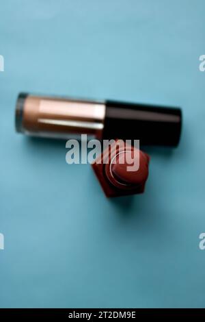 Kosmetikbox, Set mit weiblicher Kosmetik vom roten Lippenstift und Textmarker auf blauem Hintergrund. Flache Lagen. Draufsicht. Stockfoto