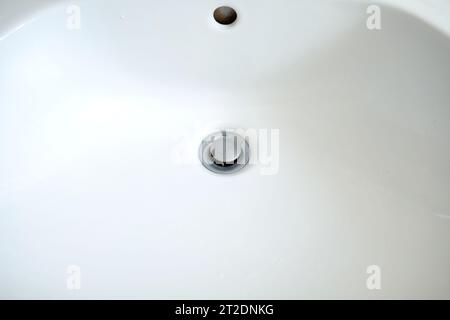 Abflussöffnung für Waschbecken im Badezimmer mit Metallstopfen. Draufsicht, Nahaufnahme, keine Leute Stockfoto