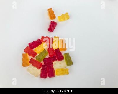 Süßes Dessert. Gummibären in Form eines Weihnachtsballs. Helle, farbige, voluminöse Gummigummis. Ungewöhnliche Form auf weißem mattem Hintergrund. Köstlich Stockfoto