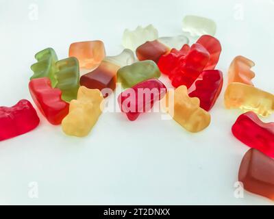 Gummibonbons auf weißem mattem Hintergrund. Auf dem Tisch liegt Marmelade in Form von gelatineartigen Bären. Köstliche süße Süßigkeiten für Kinder und Erwachsene Stockfoto