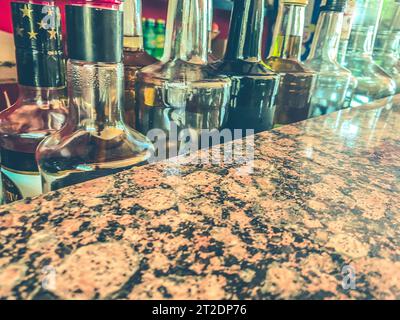 Herstellung kleiner Liköre auf der Grundlage von Ahornsirup. Viele Flaschen mit reinem Alkohol sind nicht gekennzeichnet. Flaschen in einer Reihe platziert. Stockfoto