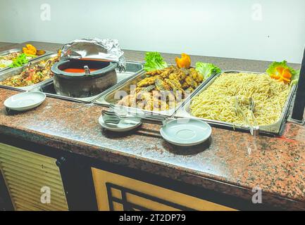 Snacks auf dem Tisch im Hotel. Große Auswahl an Speisen für Touristen zum Mittagessen. Spaghetti in einem Topf, Speisesauce, Fleisch und gemischtes Gemüse. Stockfoto