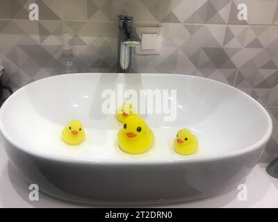 Schöne gelbe Gummienten für das Badezimmer sitzen im Waschbecken. Stockfoto