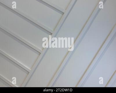 Weißes profiliertes Metallblech wie Holzwand aus diagonalen Dielen. Stockfoto