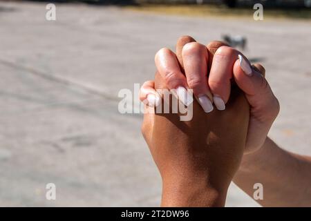 Hände verschiedener Ethnien, Afrikaner und Europäer, die sich gegenseitig umarmen. Unionskonzept Stockfoto