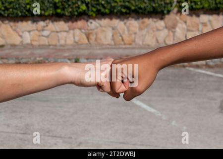 Hände verschiedener Ethnien, afrikanischer und europäischer Herkunft, mit Faust zu Faust in einem Konzept der Freundschaft oder Kameradschaft Stockfoto